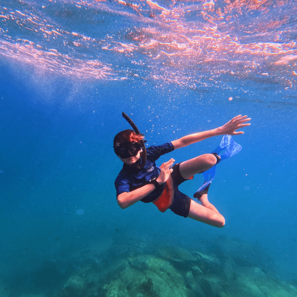 A child snorkeling over a shallow reef